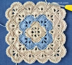 a crocheted square with blue and white squares on it, next to a pair of scissors