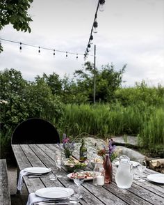 an outdoor table set with plates and silverware