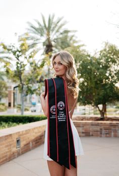 a woman wearing a black and red graduation stole