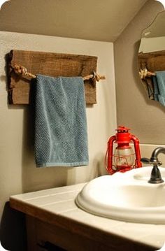 a bathroom sink with two towels hanging on the wall and a red light in the mirror