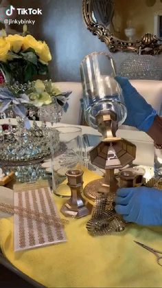 a person in blue gloves is working on a table with glassware and other items