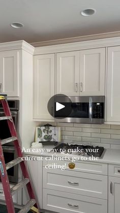 a kitchen with white cabinets and a red ladder in the middle, next to an oven