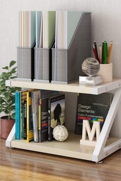 a book shelf with books, magazines and other office supplies on it next to a potted plant