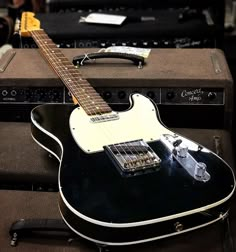 an electric guitar sitting on top of two amps