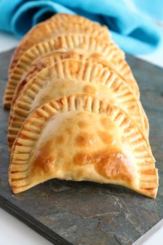 three pastries sitting on top of a slate board