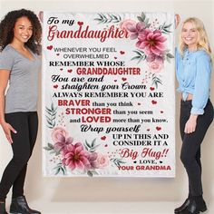 two women standing in front of a granddaughter sign