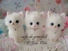 three white kittens with blue eyes are sitting on a doily in front of pink flowers