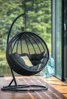 a hanging egg chair in front of a window