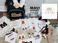 baby clothes and diapers are laid out on the floor next to a bag with a sign that says mavi ahmir