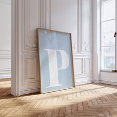 an empty frame sitting on the floor in front of a wall with a letter p