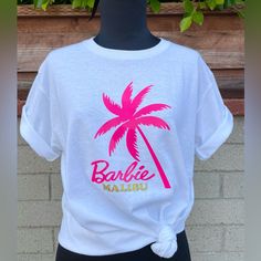 Just In & Selling Fast! It Is The Perfect Tee To Wear To Go Watch The Barbie Movie & All Summer Long -New, Never Used - Size S, M, L, Xl -Soft Cotton Ribbed Crew Neck Tee. -Composition 100% Cotton -Packaged In Poly Bag - Ships Next Day -Proudly Printed In With Love Pink Cotton Top With Palm Tree Print, Pink Screen Print Top For Beach, Pink Screen Print Tops For Beach Season, Pink Text Print Vacation Tops, Pink Palm Tree Print Short Sleeve Top, Fun Pink Top For Beach Season, Fun Pink Tops For Beach Season, Pink Cotton Tops For Vacation, Pink Graphic Print T-shirt For Vacation