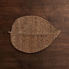 a woven leaf on a wooden surface