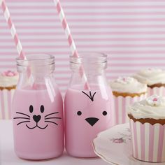 pink cupcakes and milk bottles with cat faces painted on the side, sitting next to each other