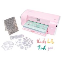 a pink cricut machine with thank you stickers and dies on it