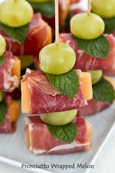 small appetizers are arranged on a plate with toothpicks and green olives