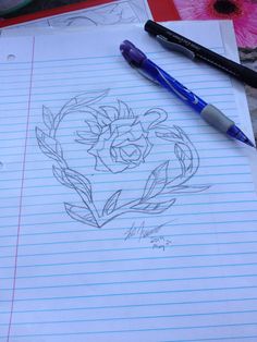 a drawing of a rose on lined paper next to a pen and flower vases