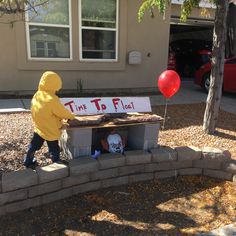 a child in a yellow raincoat standing next to a sign that says time to float