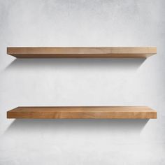 two wooden shelves against a white wall with no one on them or the shelf is empty