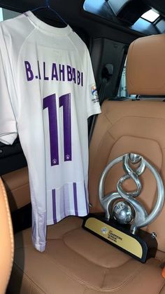 a car seat with a jersey and trophy on it