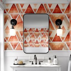 a bathroom vanity with two sinks and a large mirror above it, in front of a patterned wall