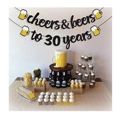 a table topped with cupcakes and cakes next to a sign that says cheers & beers to 30 years