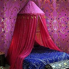 a pink canopy bed in front of a purple wall with sequins on it