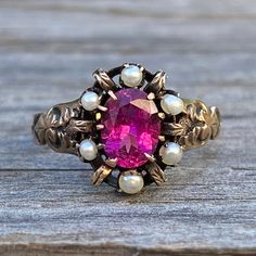 Details: Sweet Pink Tourmaline and seed pearls set in 14K yellow gold. The tourmaline is a vibrant rich pink color. The Victorian setting has a sweet scroll pattern on the shoulders and a lovely claw setting. This sweet ring has engraving with the date April, 9, 96 (circa 1896). Please ask all necessary questions prior to placing an order. Measurements: The size is 6 1/4 US and can be sized for a fee. The tourmaline measures 7mm by 5mm. The ring weighs 2 grams. Condition: The overall all conditi Victorian Pink Ruby Ring For Anniversary, Pink Victorian Ruby Ring For Anniversary, Victorian Pink Rose Cut Diamond Jewelry, Heirloom Ruby Jewelry In Pink, Victorian Style Pink Ruby Ring Gift, Antique Rings Engagement, Vintage Rings Antiques, Antique Rings Vintage, Filigree Ring Gold