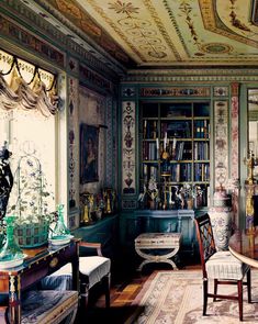 the room is decorated in green and gold with ornate designs on the ceiling, along with antique furniture