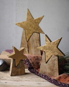 three wooden stars sitting on top of a table next to a mouse and christmas tree