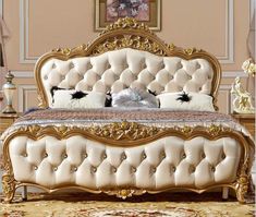 an ornate bed with gold trimmings and white pillows on the headboard, in a bedroom