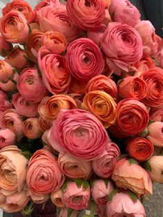 an arrangement of pink and orange flowers in a vase