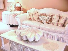 a living room filled with white furniture and pillows