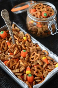 a container filled with halloween pretzels and candy cornflakes on top of a table