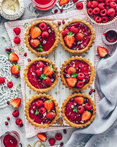 strawberry tarts are arranged on top of a table