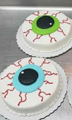 three decorated cakes sitting on top of a counter