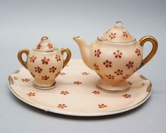 This vintage miniature tea set is a stunning addition to any collection. The set includes a tea pot/teapot, sugar bowl, platter and lids for both the tea pot and the sugar bowl. The intricate details and multi-color design make this set a must-have for any Victorian style lover. The ceramic and porcelain materials add a touch of elegance to the set, and the unmarked brand adds to the mystery and intrigue of the piece. The set is an original, post-1940 piece, making it a rare find. Perfect for collectors or as a unique gift, this tea set is sure to impress. 1947-1952. Tea pot stands 2" and is 2 1/4" across its widest point. The sugar bowl stands 1 1/2" tall and is 1 3/8" across its widest point. The platter measures 3 7/8" wide. Shows wear and age. Please see photos for conditions. Thanks f Porcelain Tea Set, Vintage Miniatures, Tea Pot, Victorian Style, Sugar Bowl, Intricate Details, Victorian Fashion