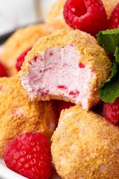 a plate with some raspberry doughnuts and fresh raspberries on it