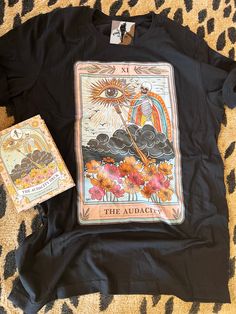 a t - shirt with an image of the sun on it next to a book