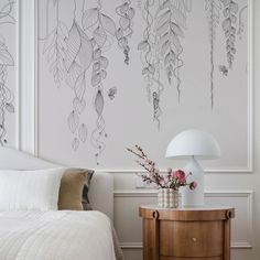 a bedroom with a bed, nightstand and wallpaper