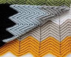 crocheted blankets are stacked on top of each other in different colors and patterns