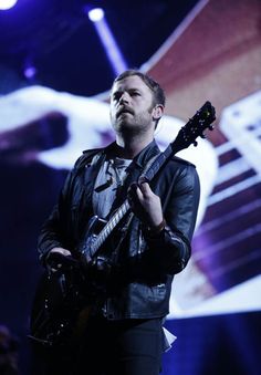 a man with a guitar standing on stage