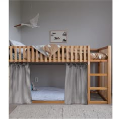 a bunk bed with curtains hanging from it's sides and the bottom half open