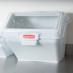 an ice chest sitting on top of a counter next to a container filled with water