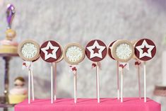 cake pops with stars on them sitting on top of a pink table