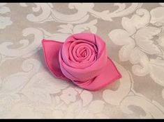 a pink flower sitting on top of a bed