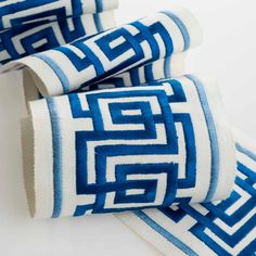 three blue and white towels folded on top of each other, one with an interlocked design