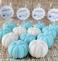 blue and white pumpkins are sitting on a table with tags in front of them