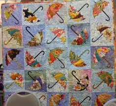 a quilted wall hanging with umbrellas on it