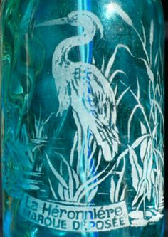 a blue glass bottle with a bird on it