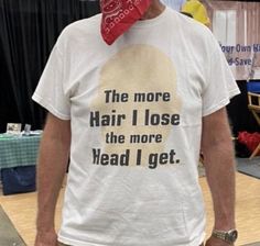 a man wearing a t - shirt that says the more hair i lose the more head i get